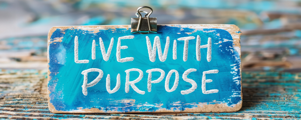 Blue wooden board that says live with purpose 