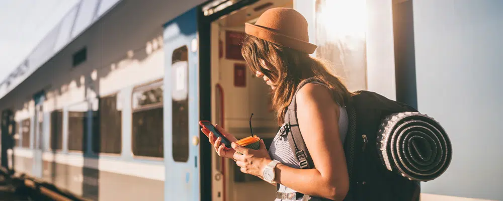 Women exiting a train traveling with a phone in hand
