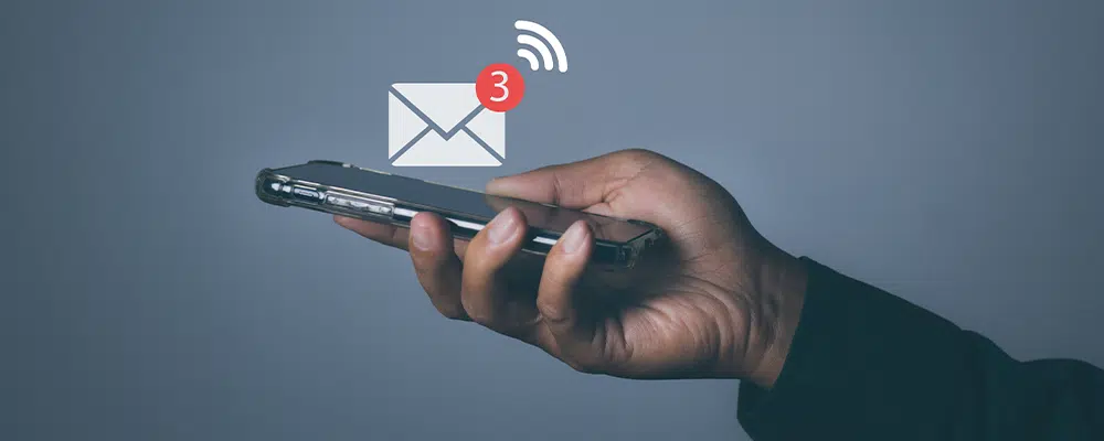 Man holding phone with email notifications