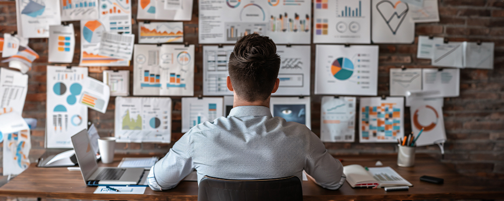 Man sitting at desk with a lot of tasks ahead of him