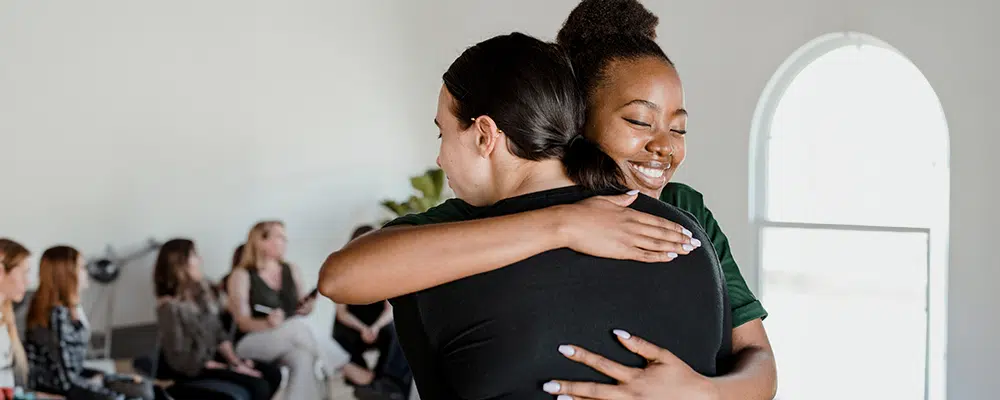 Two people hugging each other