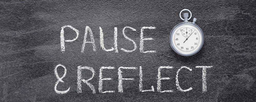 A Chalkboard that has Pause and Reflect written on it