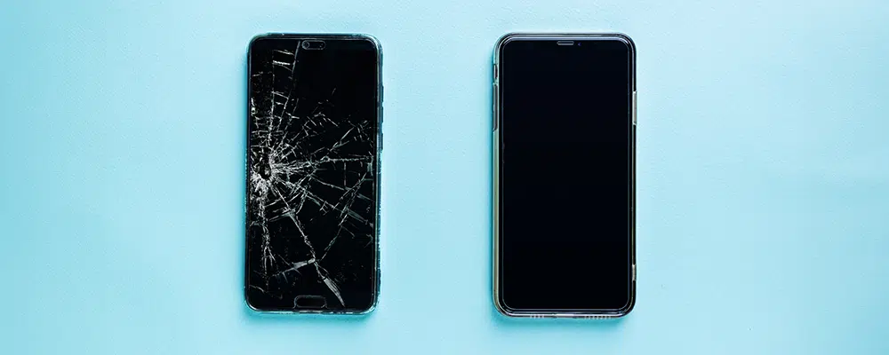 Modern touch screen smartphone with broken screen and new one on blue background, top view